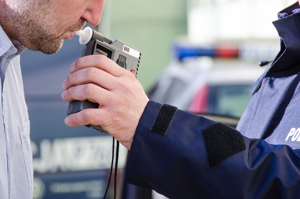 man blowing into a breathalyzer test
