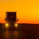 A truck driving at dusk. Build a claim for compensation with a Davie truck accident lawyer.