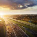 Cars drive on expressway at sunset in Florida.