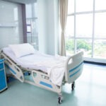 An empty bed in a hospital room.