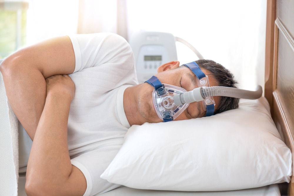 A man sleeping while wearing a CPAP mask.
