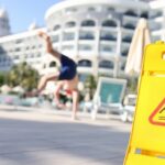 wet floor caution sign with person falling on slippery surface nearby