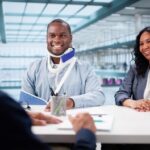 injured man wearing neck brace and arm sling meeting with legal professional