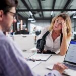 injured woman with arm brace meeting lawyer reviewing health insurance claim form
