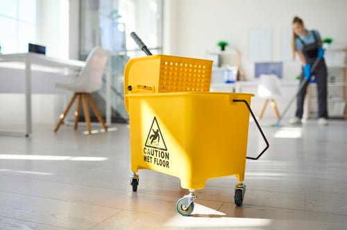 Caution Wet Floor mop bucket on wheels with cleaner mopping office floor