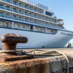 Ocean Adventurer cruise ship docked at port with mooring bollard and dock workers