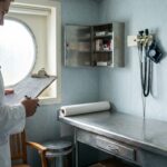 Ship's Medical Staff member reviewing clipboard in cruise ship medical bay