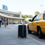 taxi cab parked at MIA Miami International Airport arrivals curb with luggage