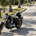 Harley-Davidson motorcycle with helmet resting on seat parked near curb