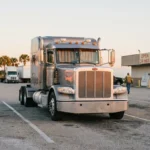 Peterbilt semi-truck cab parked at truck stop with Open 24 Hours sign