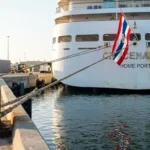 cruise ship docked at port with mooring rope tied to bollard