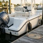 Center console boat with Yamaha outboard motor docked beside coiled rope